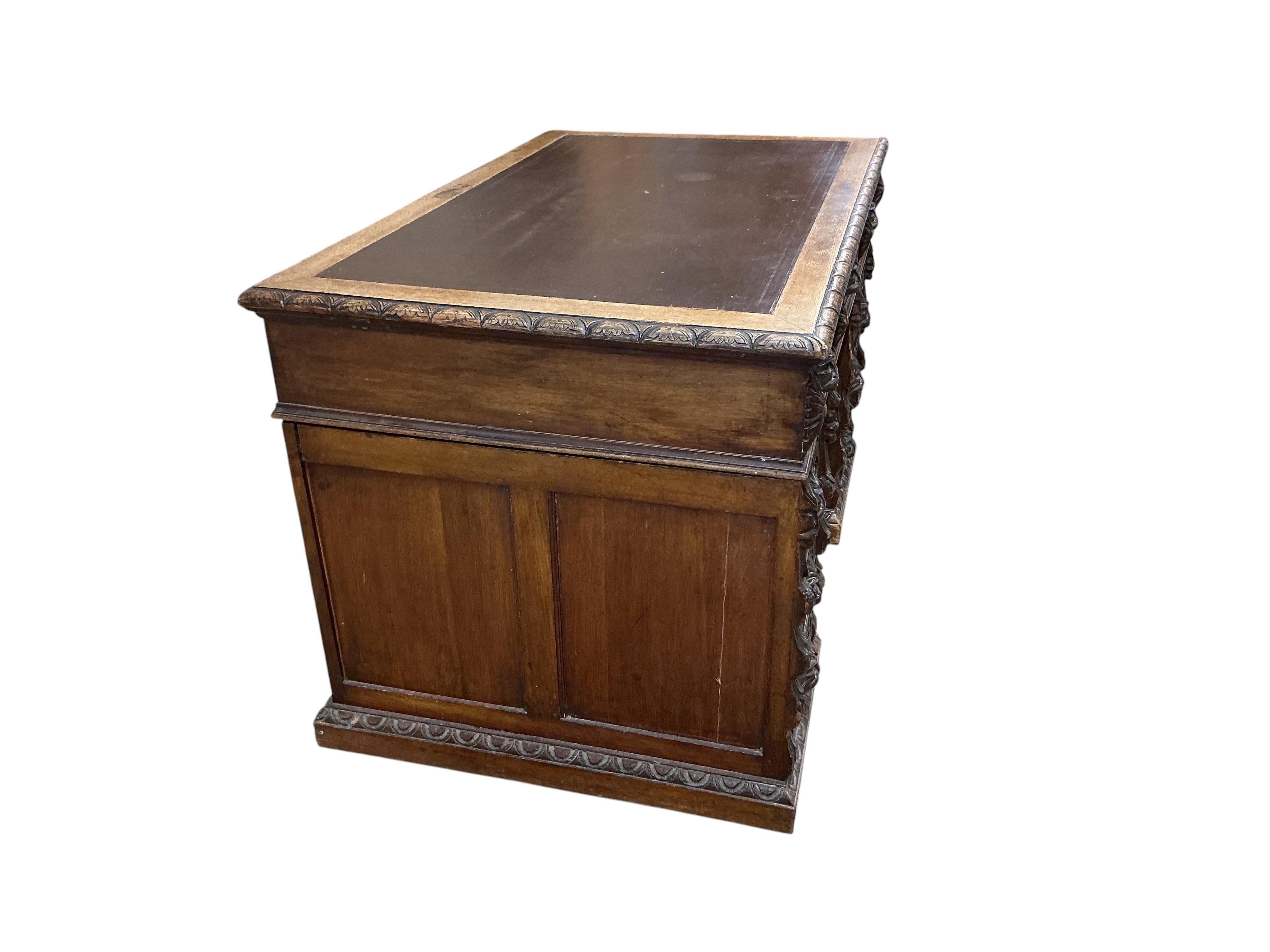A late Victorian Flemish carved oak pedestal partners desk, width 121cm, depth 75cm, height 76cm
